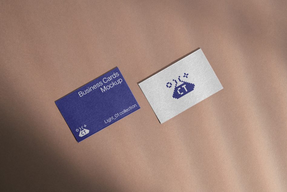 Navy blue business card next to cream colored card on warm neutral surface